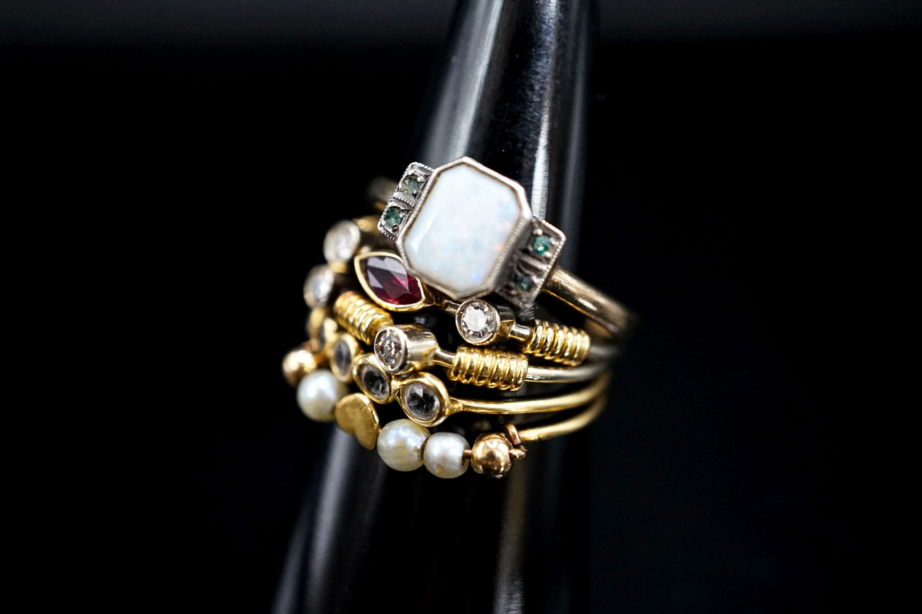 A 9ct and 'silver' white opal and gem set ring and four other thin shank yellow metal and gem set rings, gross 6.4 grams.